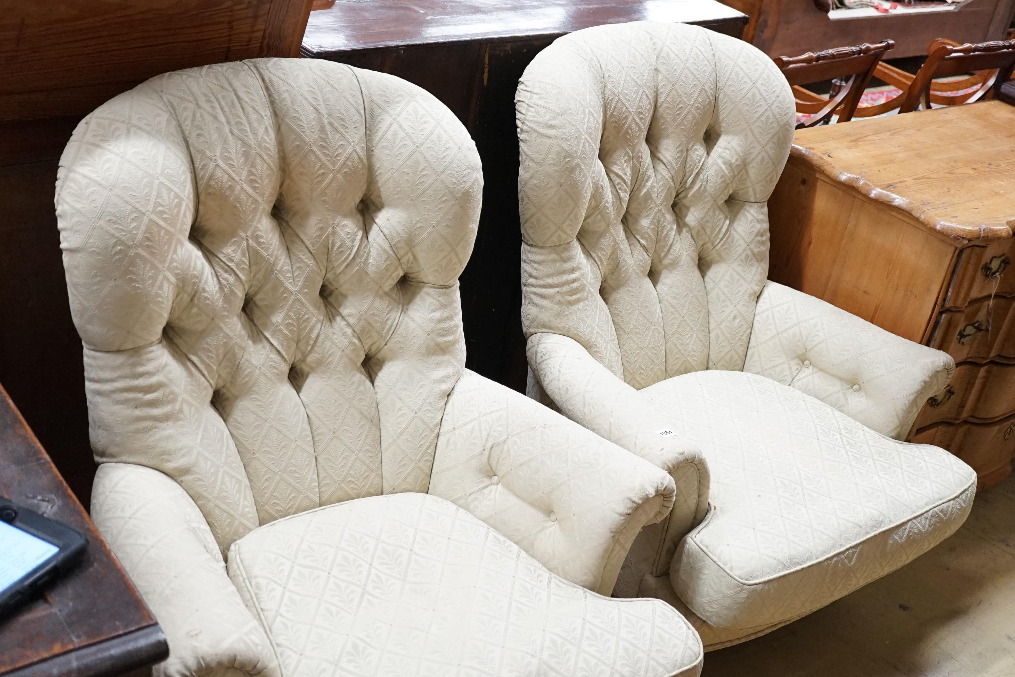 A pair of Liberty of London Victorian style button back armchairs with mahogany legs and brass castors, width 83cm, height 100cm